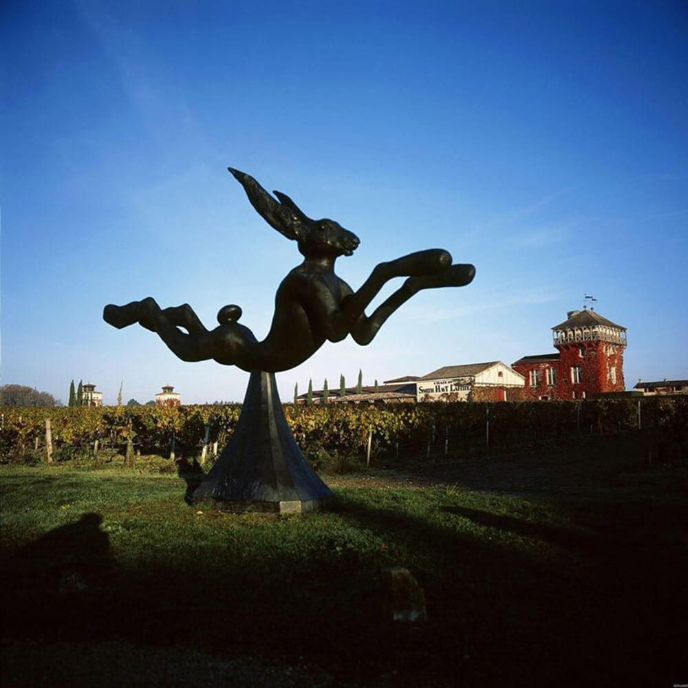 Leaping Hare Statue in bronze with elongated limbs and dynamic leap over sculptural support