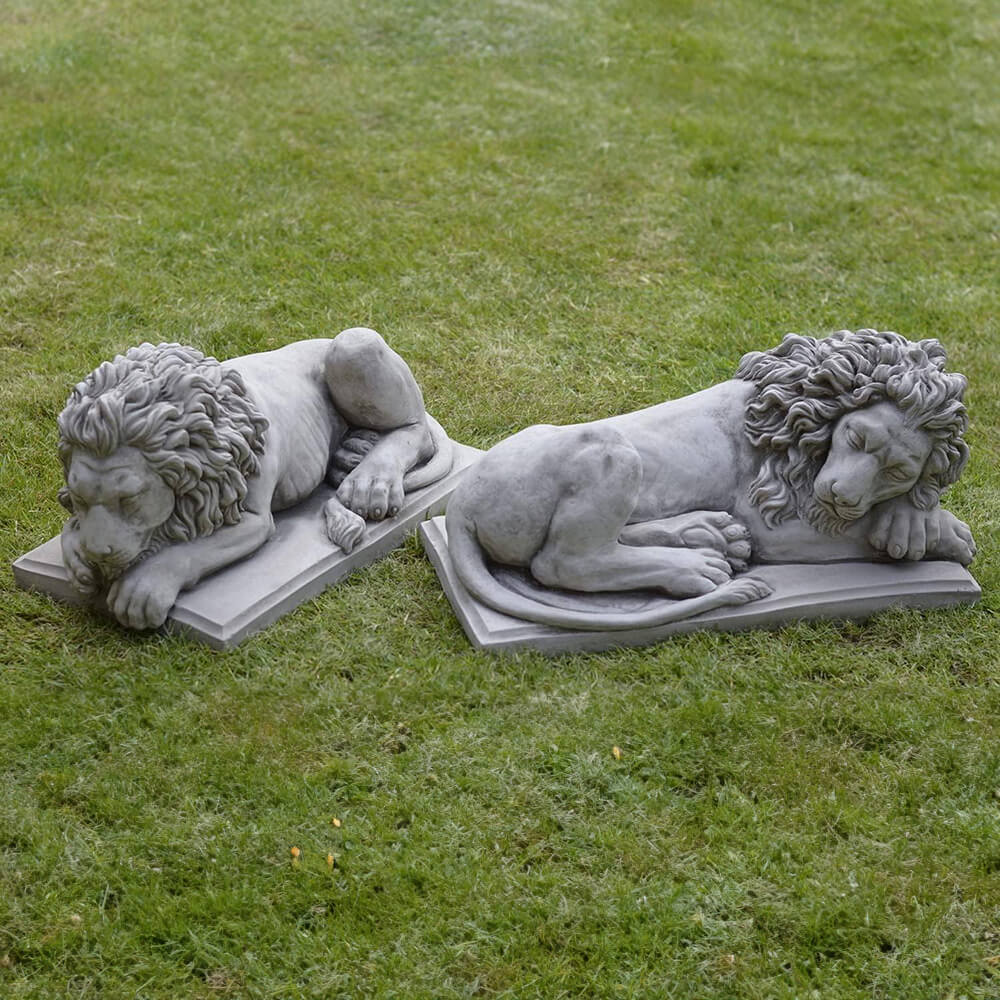 Pair of Sleeping Lion Sculptures in marble placed on grass