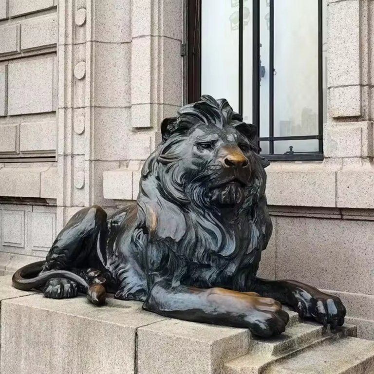 gran estatua de león de bronce para exteriores en pose yacente