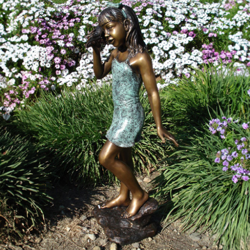Statue en bronze de la jeune fille écoutant la coquille dans le jardin
