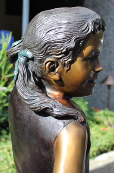 Statue frère et sœur : fille en bronze tirant une charrette